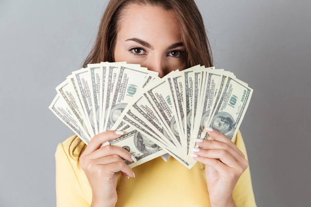 Beautiful young caucasian lady holding money in hands - Fotó, kép