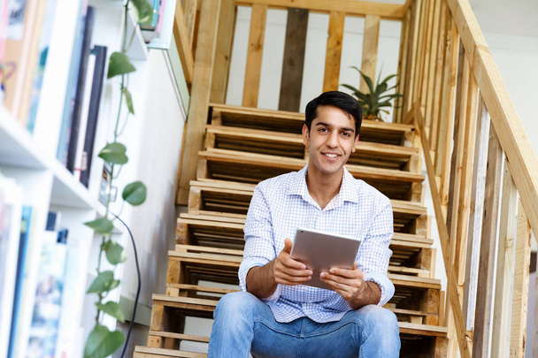 Portrait of young man sitting at the stairs in office - Φωτογραφία, εικόνα