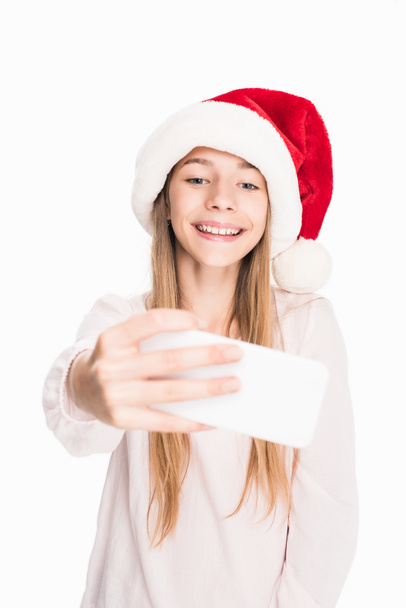 teenager in santa hat taking selfie - 写真・画像