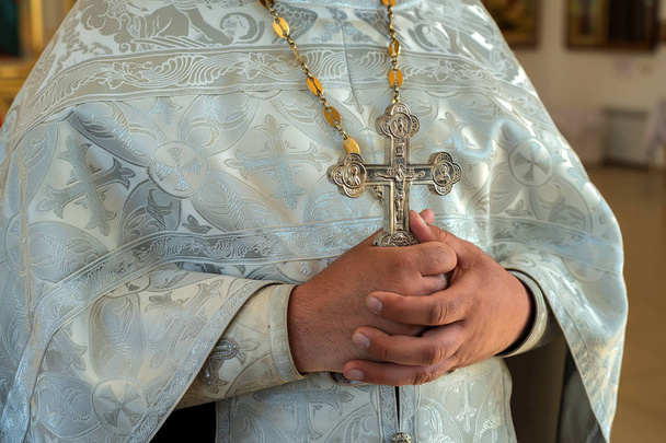 Ortodoxo sacerdote cristiano sostiene cruz
 - Foto, Imagen