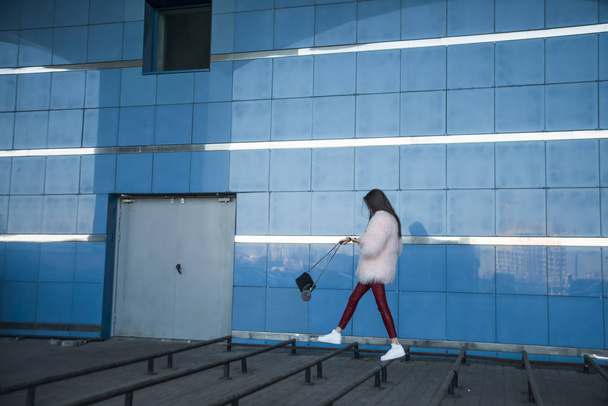 nő séta kék fal - Fotó, kép