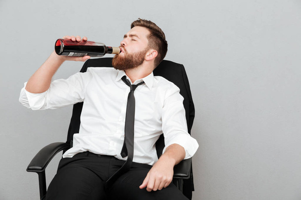 Tired young businessman sitting in office chair - Photo, Image