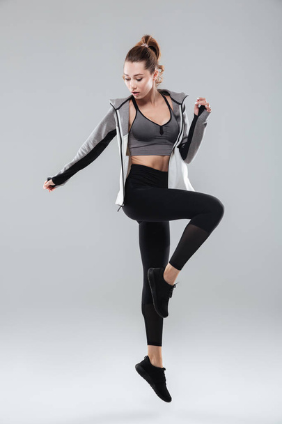 Full length portrait of a healthy woman in sportswear posing - Foto, afbeelding