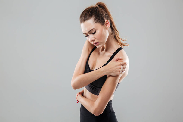 Young fitness woman having shoulder pain - 写真・画像