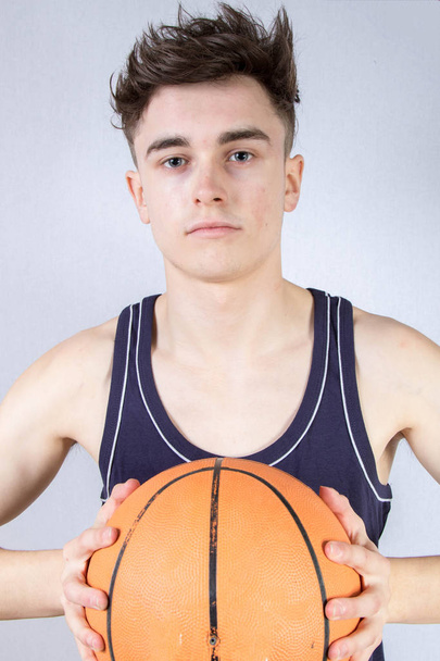Caucasian teenage boy holding a basketball isolated - Foto, Imagem