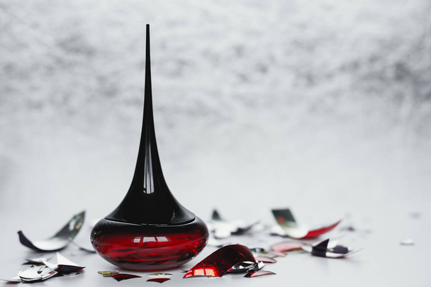 Frasco de perfume rojo sobre fondo claro
 - Foto, imagen