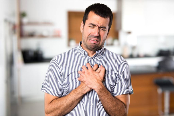 Handsome man with heart pain inside house - Photo, Image
