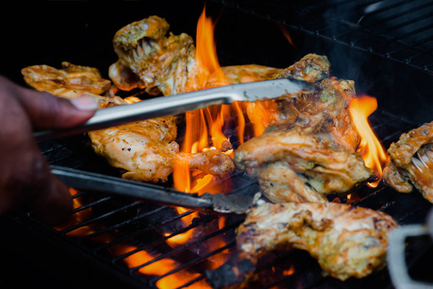 Chef cooking jerk barbecue BBQ chicken on the grill hand turning food - Photo, Image