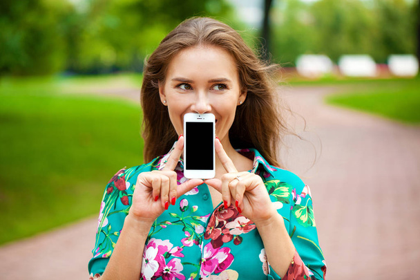 Young beautiful girl showing your smartphone screen - Foto, Imagen