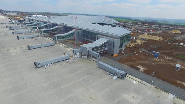 滑走路を持つ空港建設。空港の滑走路の眺めになる建設現場。労働者は、新しい空港と特別な装置を構築します。空港の建設と空の雲 - 写真・画像