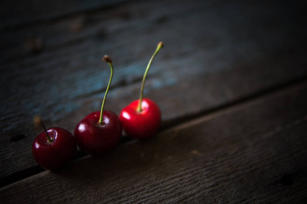 Cherry on wooden board. Tree cherries, selective focus - Φωτογραφία, εικόνα
