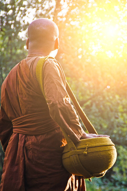 Un monje budista va por limosna temprano en la mañana
.  - Foto, Imagen