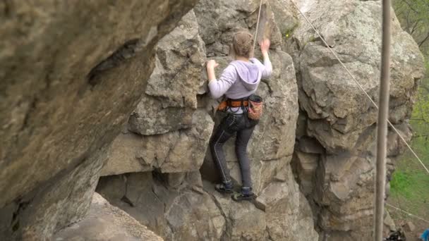 Tyttö kalliokiipeilyä luonnossa
 - Materiaali, video