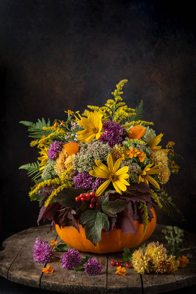 beautiful autumn flowers bouquet in pumpkin. Fall still life. - Fotó, kép