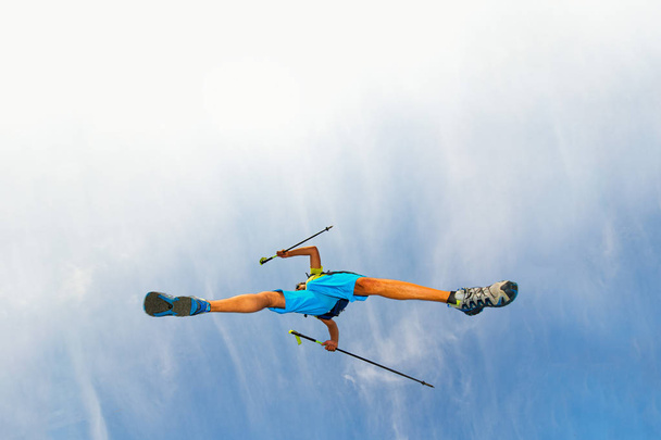 Mladý muž sportovec dělá skok s holí na nordic walking - Fotografie, Obrázek