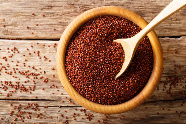 Γκρο πλαν οργανικό ακατέργαστο κόκκινο quinoa σε ένα ξύλινο μπολ. οριζόντια επάνω - Φωτογραφία, εικόνα