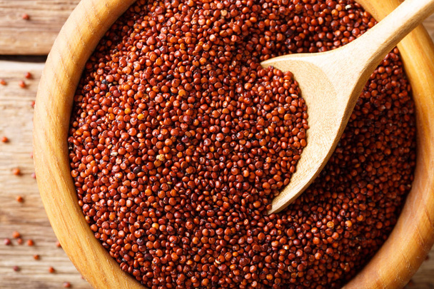 Dry red quinoa close up in a wooden bowl. horizontal top view - Fotó, kép
