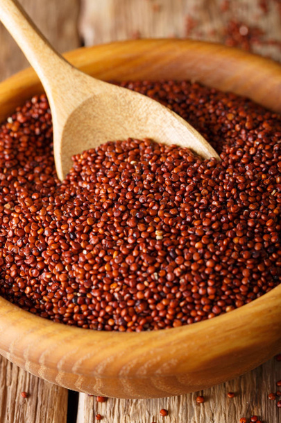 Dry red quinoa close up in a wooden bowl. vertical - Foto, Bild
