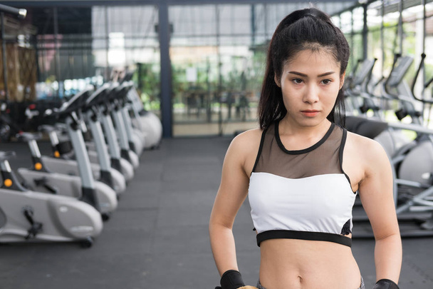 young woman standing with hands on hip in fitness center. female - 写真・画像