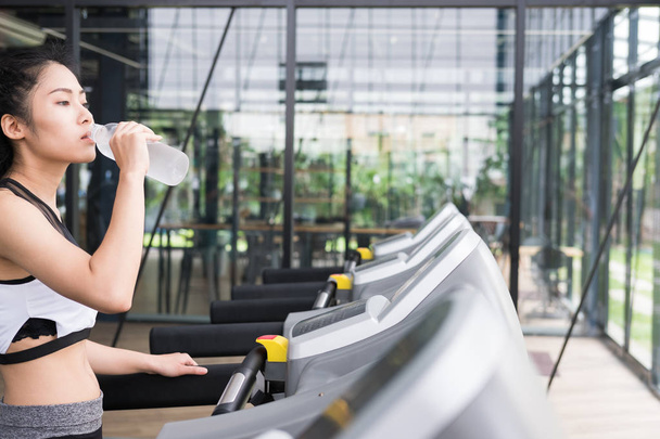 young woman drinking water in fitness center. female athlete fee - Photo, Image