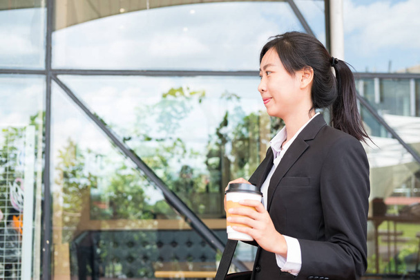 donna d'affari felice che tiene il caffè fuori dall'edificio degli uffici. beau
 - Foto, immagini
