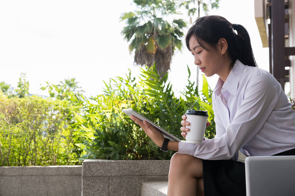 femme d'affaires tenant tablette numérique & café à l'extérieur du bureau bui
 - Photo, image