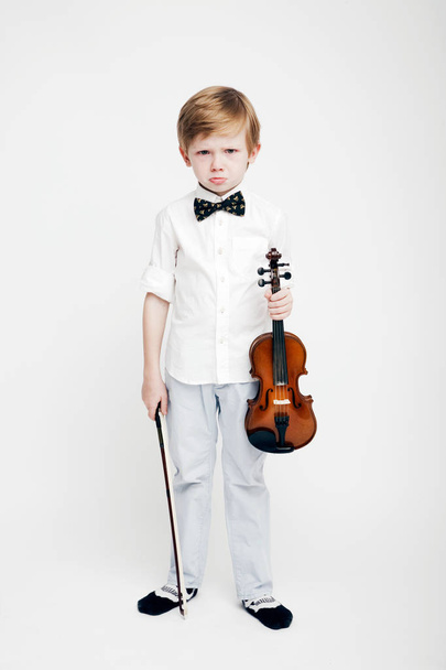 Little cute red-haired boy with a violin in his hands - Foto, Imagem