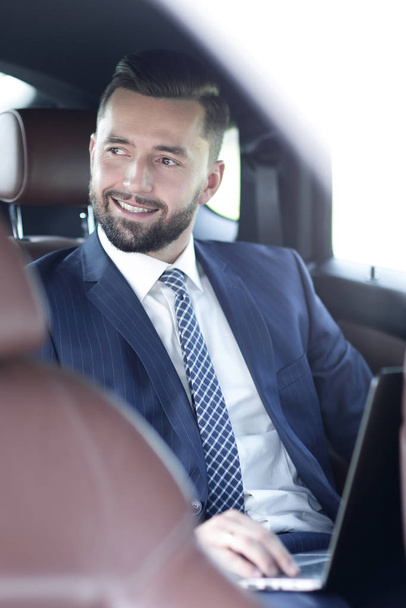 Portret van een zakenman in de achterbank van een auto - Foto, afbeelding