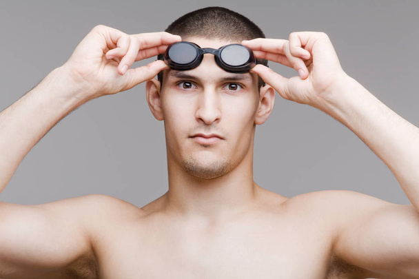 Young swimmer adjusts his goggles - 写真・画像