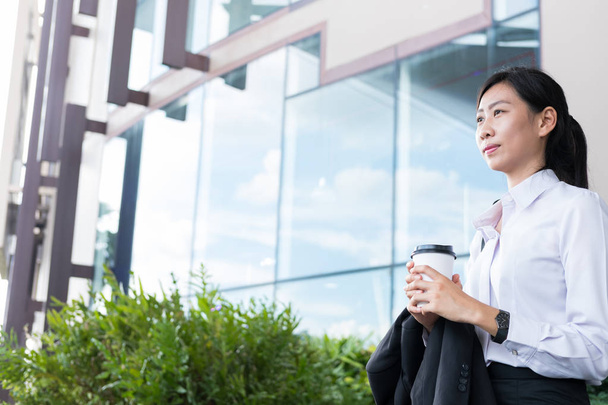 businesswoman holding coffee outside office building. beautiful  - Photo, Image