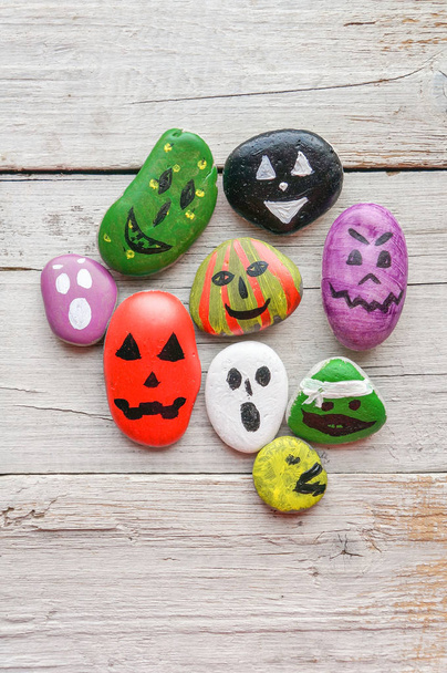 Halloween background with funny painted stones like ghosts - Фото, изображение