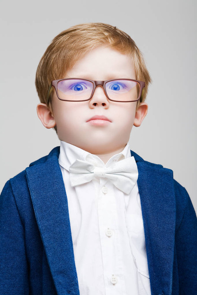 The red-haired kid with glasses puzzled - Foto, afbeelding