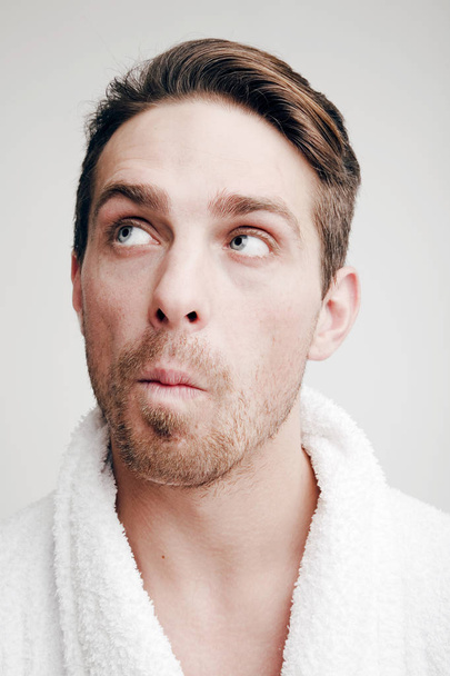 Emotions. Portrait of a Man with a puzzled face in bathrobe - Zdjęcie, obraz