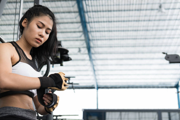 junge Frau mit Handschuhen im Fitnesscenter. Sportlerin vor - Foto, Bild