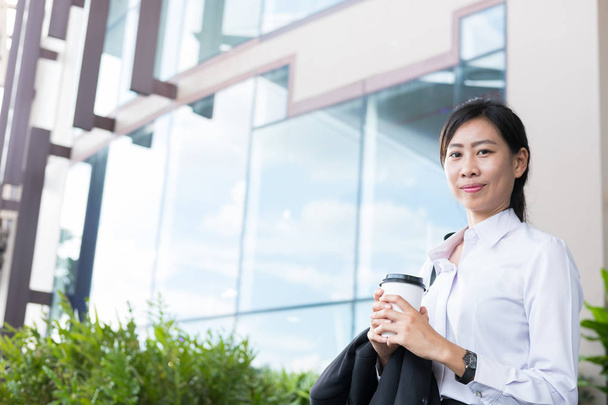 businesswoman holding coffee outside office building. beautiful  - Photo, Image