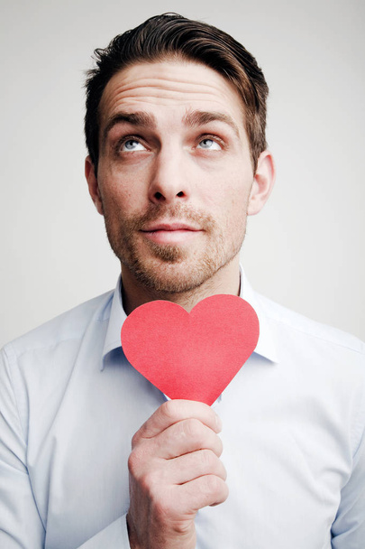Valentine's Day. Emotions. Portrait of a man with a red heart in hand - Foto, Imagen