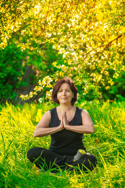 hermosa mujer haciendo yoga al aire libre en verde hierba
 - Foto, Imagen