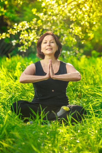 mooie vrouw doet yoga buiten op gras - Foto, afbeelding