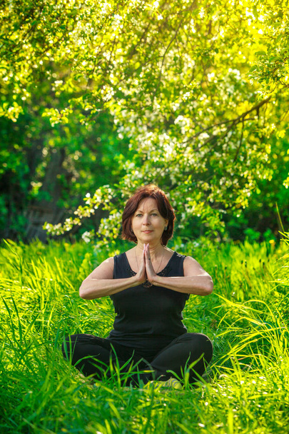 hermosa mujer haciendo yoga al aire libre en verde hierba
 - Foto, Imagen