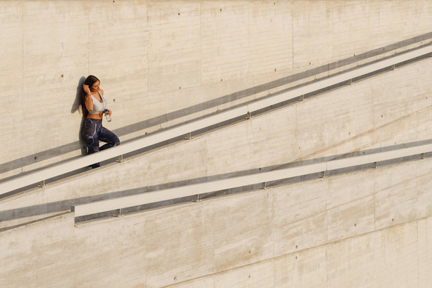 Sporty woman taking a workout rest for drinking water - Fotó, kép