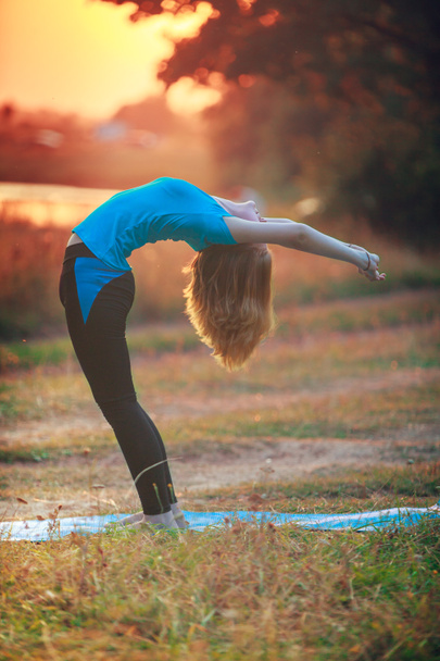 bella donna che fa yoga all'aperto su erba verde
 - Foto, immagini