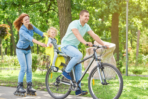 Happy family riding bike at the park - Foto, afbeelding
