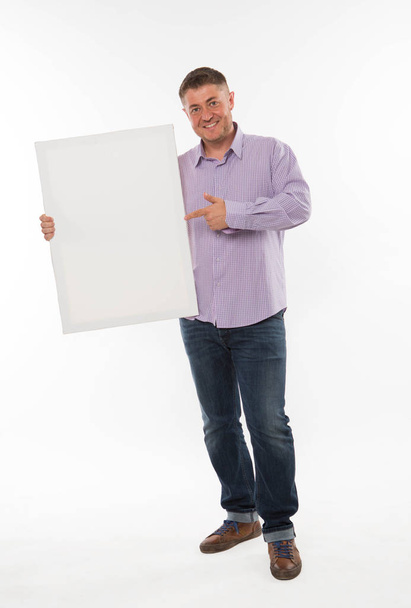 Young happy man showing presentation, pointing on placard. - Valokuva, kuva