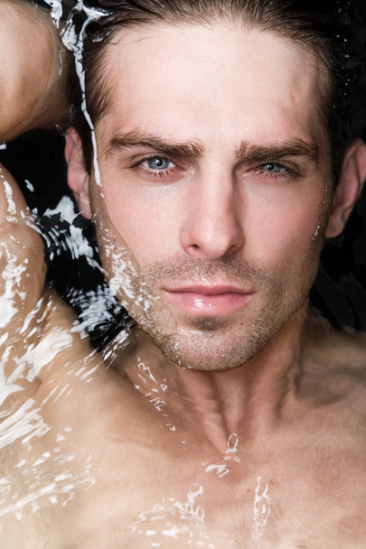 Portrait of an attractive young man in water - Фото, изображение