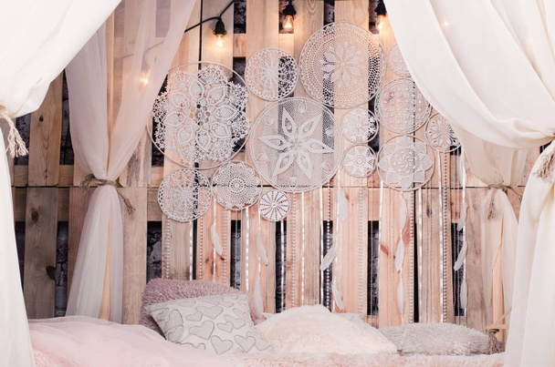 cama con cojines suaves y toldos y atrapasueños blanco
  - Foto, imagen