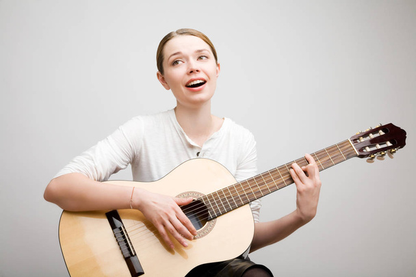 A young girl with a guitar sings a song - Foto, imagen