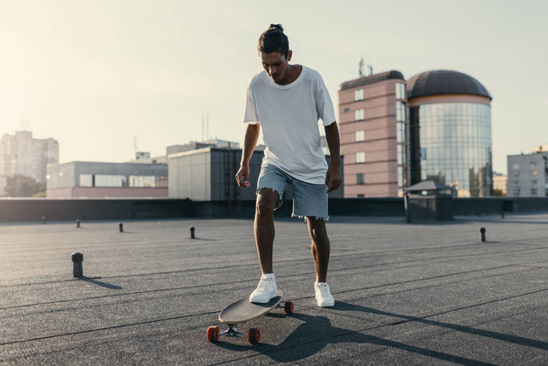 Mann fährt auf Skateboard auf Dach - Foto, Bild