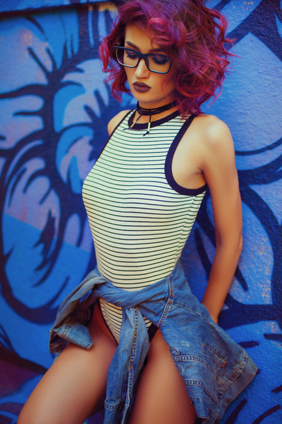 Street look of Fashion and Sexy woman with red curly hairstyle posing near graffiti wall - Fotoğraf, Görsel