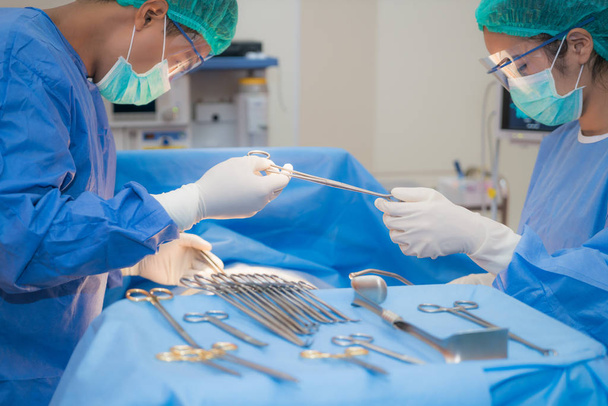 asiatischer Arzt und Assistent im Operationssaal für chirurgische Eingriffe - Foto, Bild