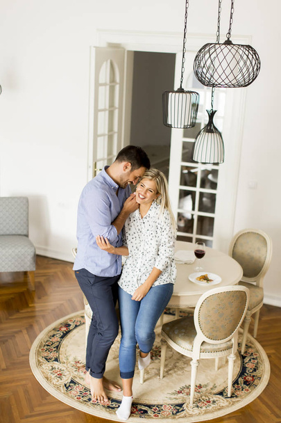 Abbracciato giovane coppia in soggiorno
 - Foto, immagini
